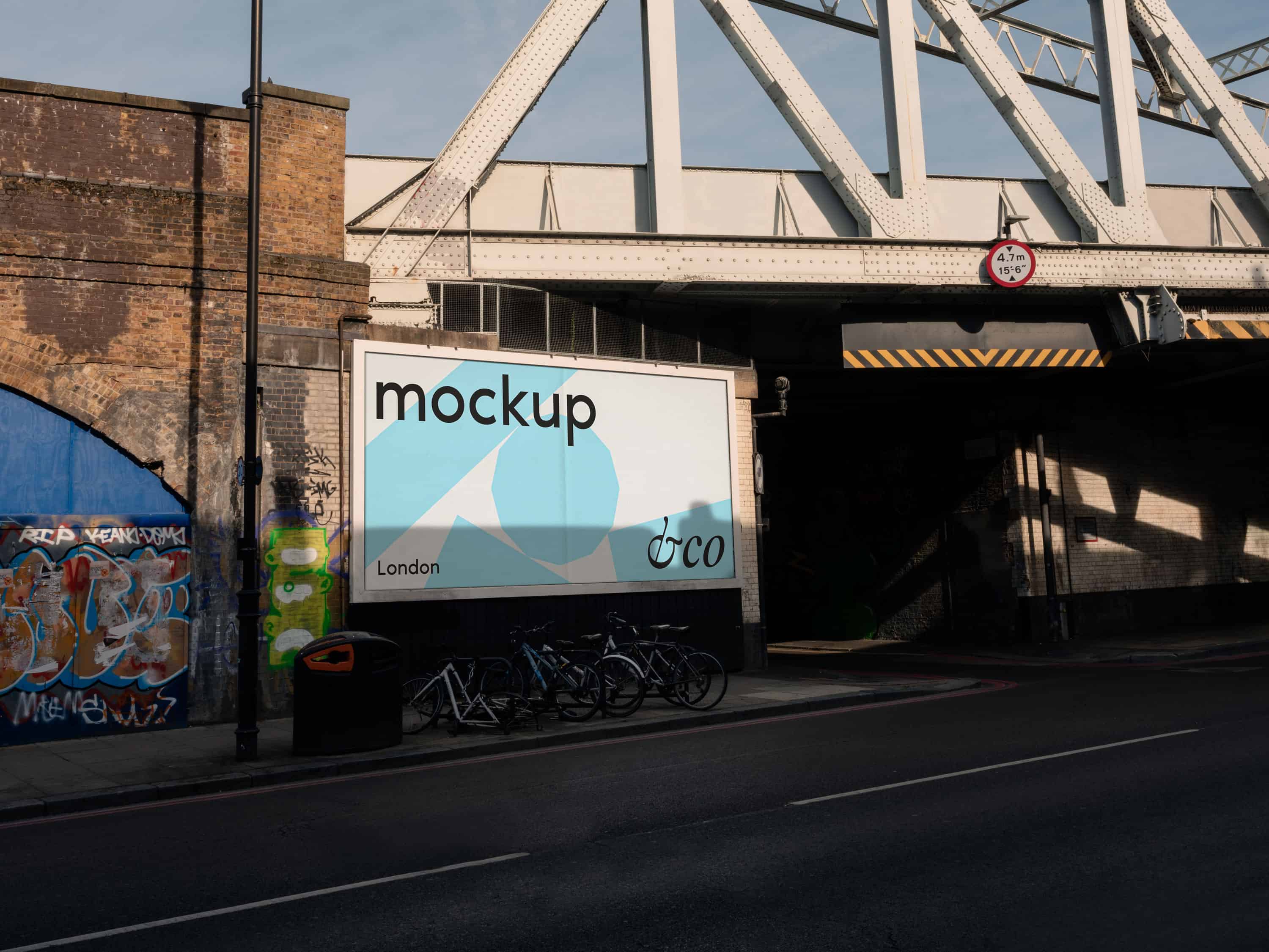 Customisable London billboard mockup shot in East London, with dramatic lighting and graffiti under a railway, ideal for street art, music branding, and urban advertising campaigns.