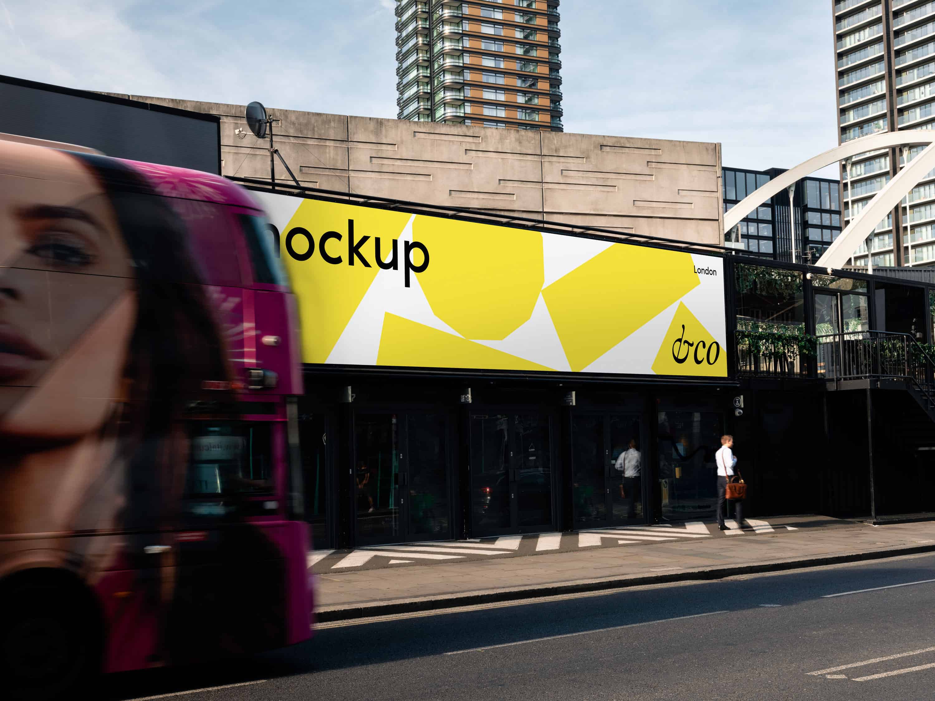 Customisable billboard mockup shot in London with a dynamic city backdrop and a London bus, ideal for presenting branding, artwork, or promotional materials in an urban environment.